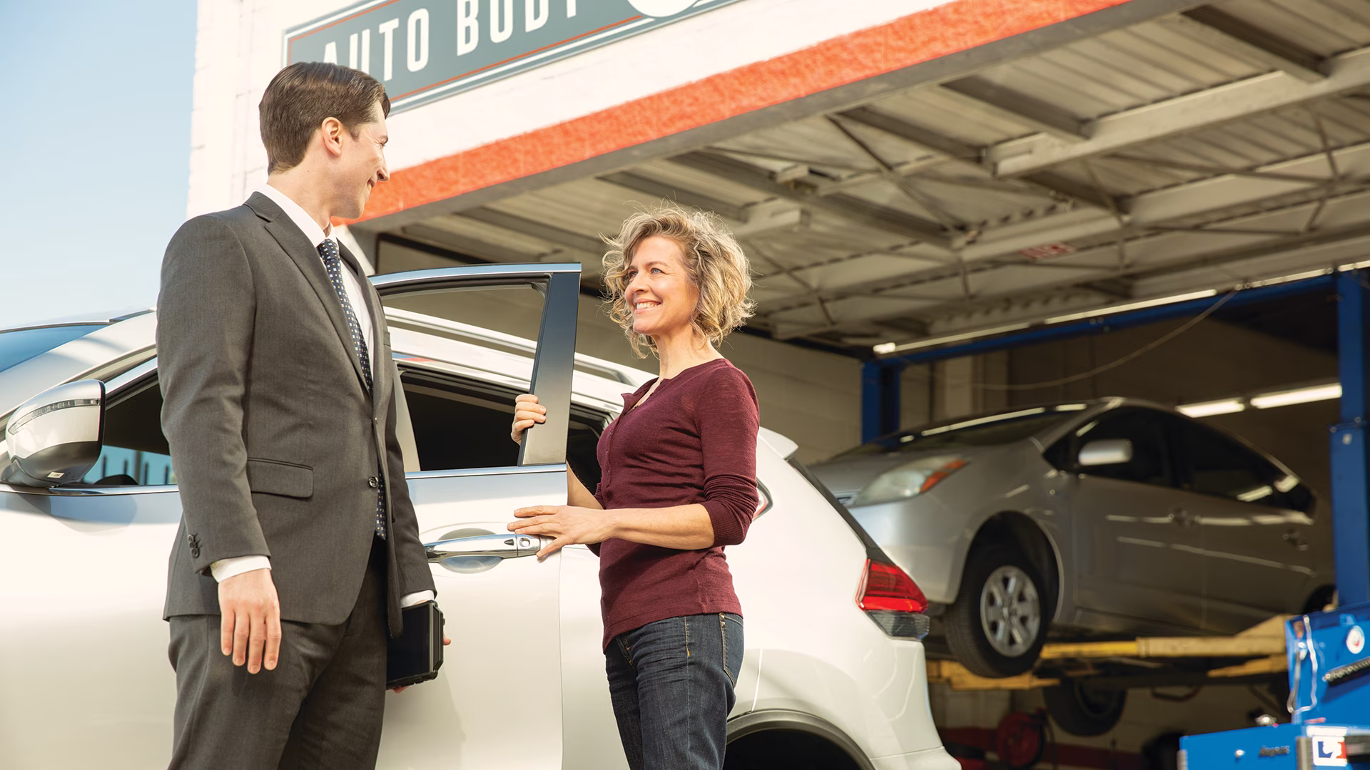 A woman passing the car keys to the autoshop employee for maintenance 